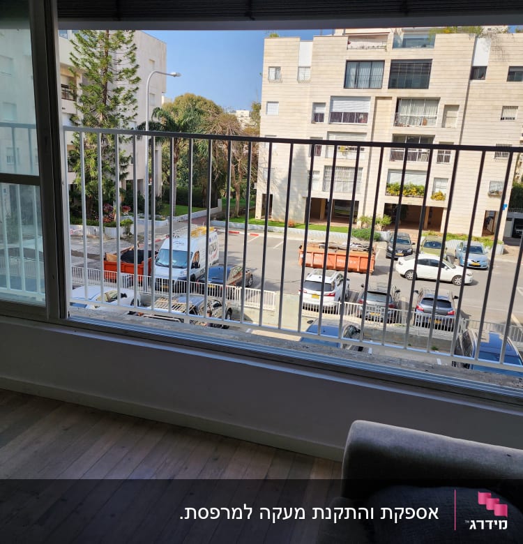 חלון עם מסגרת מתכת לבנה ונוף עירוני